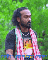 a man with a beard and a plaid scarf around his neck is wearing a t-shirt that says lon on it