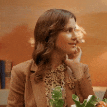 a woman sitting at a table with a glass of water and a salad