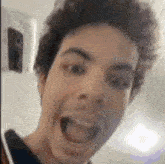 a man is making a funny face with his mouth open .