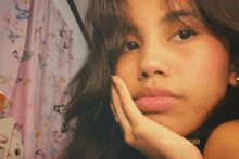 a close up of a woman 's face with a pink curtain behind her
