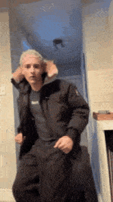 a man in a parka is dancing in a hallway