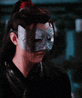 a man wearing a silver mask with a ponytail