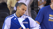 a man wearing a blue and white jacket with the word warriors on the front