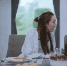 a woman sits at a table with a plate of food