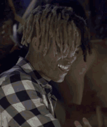 a man with dreadlocks and a choker around his neck