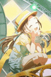 a girl with long hair wearing a yellow hat is smiling with her hands on her chin