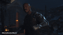 a movie poster for the mortal kombat movie shows a bald man