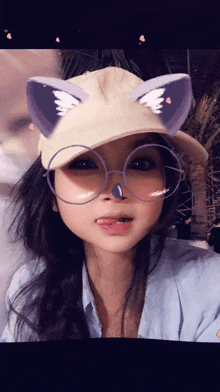 a woman wearing glasses and a hat with cat ears on it