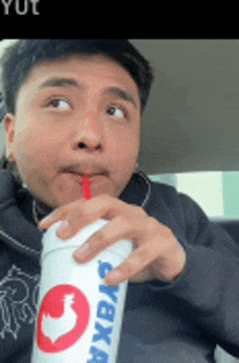 a man is drinking from a cup that says chicken