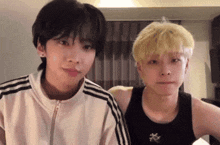 a couple of young men standing next to each other in a room .