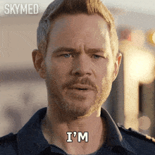 a man with a beard says " i 'm " in white letters