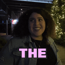 a woman is smiling in front of a sign that reads heck