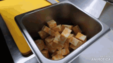 a metal container filled with cubes of cheese says made in animotica