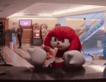 knuckles the echidna from sonic the hedgehog is eating a slice of pizza .