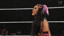 a woman in a wrestling ring with a pink bow in her hair