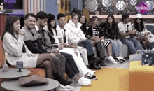 a group of people are sitting on couches in a room .