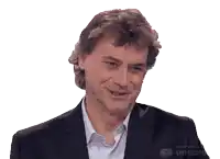 a man in a suit is smiling with the words made with unscreen visible behind him