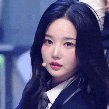 a close up of a girl wearing a school uniform and a microphone