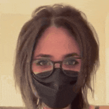 a woman wearing glasses and a black face mask .