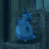 a blue cartoon character is standing on a wooden crate