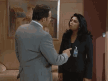 a man in a suit is hugging a woman in a black jacket