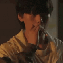 a young man is sitting at a table in a dark room .