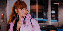 a woman wearing a pink jacket is standing in front of a sign that says discord