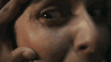 a close up of a person 's face with their hand on their forehead .