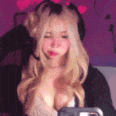 a blonde girl wearing headphones and a bra is taking a picture of herself .