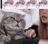 a cat is sitting next to a woman using a pen
