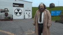 a man in a trench coat is standing in front of a building that says f diefen