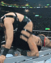 a female wrestler is laying on her back in a ring during a wrestling match