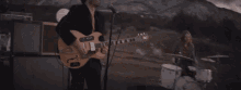 a man is playing a guitar with a sticker on it that says ' i love you ' on it