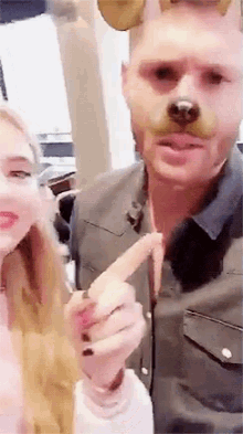 a man is wearing a dog mask and a woman is pointing at him .