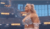 a woman is standing in front of a wrestlemania sign