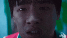 a close up of a young boy 's face with a netflix logo in the background .