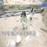 a little girl is running on a tiled floor with korean writing on it .