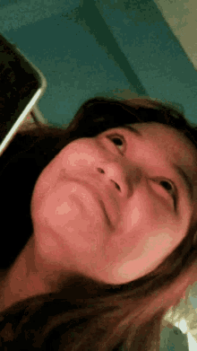 a close up of a woman 's face with her eyes looking up