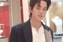 a young man in a black jacket and white shirt