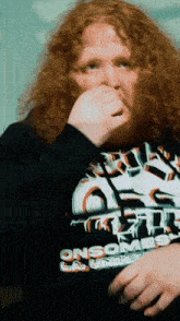 a man with red curly hair is wearing a black shirt that says onsome
