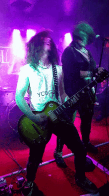 a man playing a guitar with a shirt that says you
