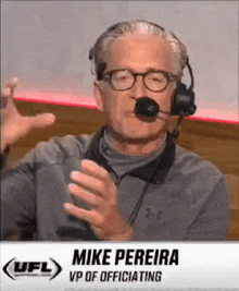 a man wearing glasses and a headset is talking into a microphone on a television .