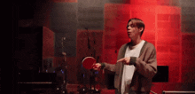 a man is holding a ping pong paddle and pointing