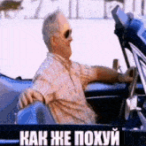 a man wearing sunglasses is driving a car with the words " как же похуй " on the side