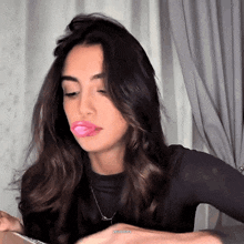 a woman with a pink bubble gum in her mouth and the word estudios visible