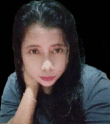 a woman with her hand on her chin looks at the camera