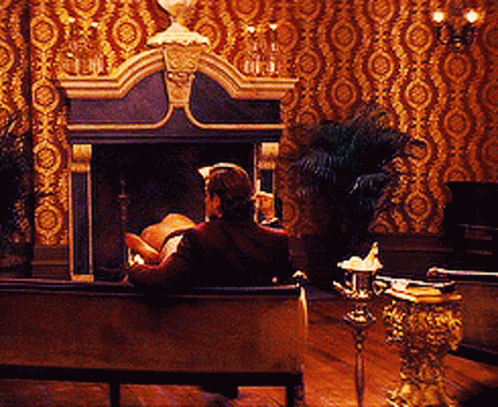 a man sits on a couch in front of a fireplace in a living room