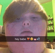 a young boy is taking a selfie with a snapchat message that says hey babe
