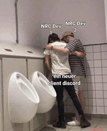 two men hugging in a public restroom with nrc dev 1 nrc dev 2 and ein neuer client discord