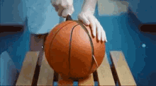 a person is cutting a basketball with a pair of scissors